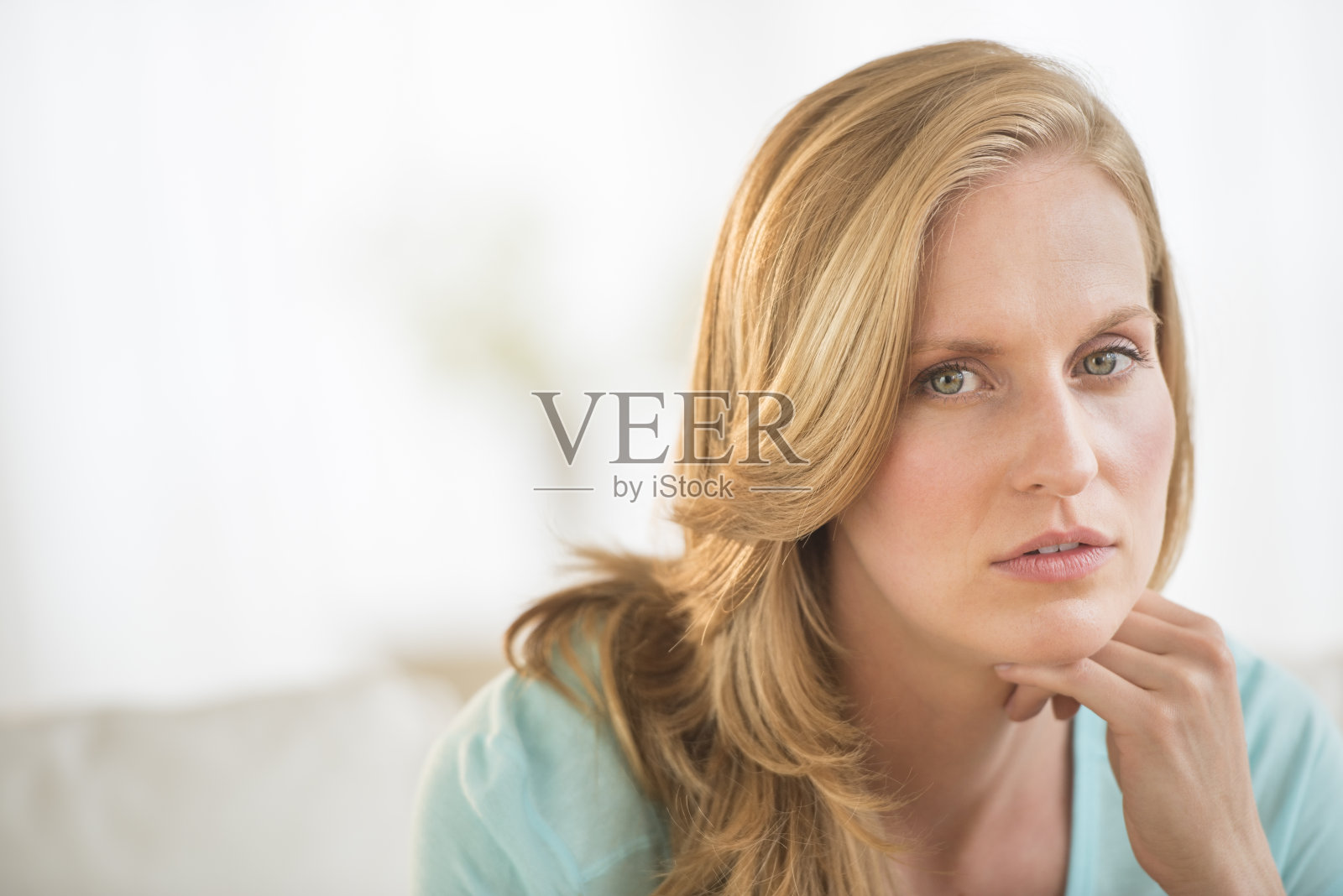 手放在下巴上的美丽女人照片摄影图片