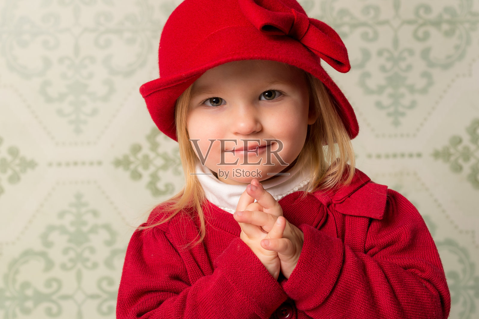 戴着帽子、双手交叉的小女孩照片摄影图片