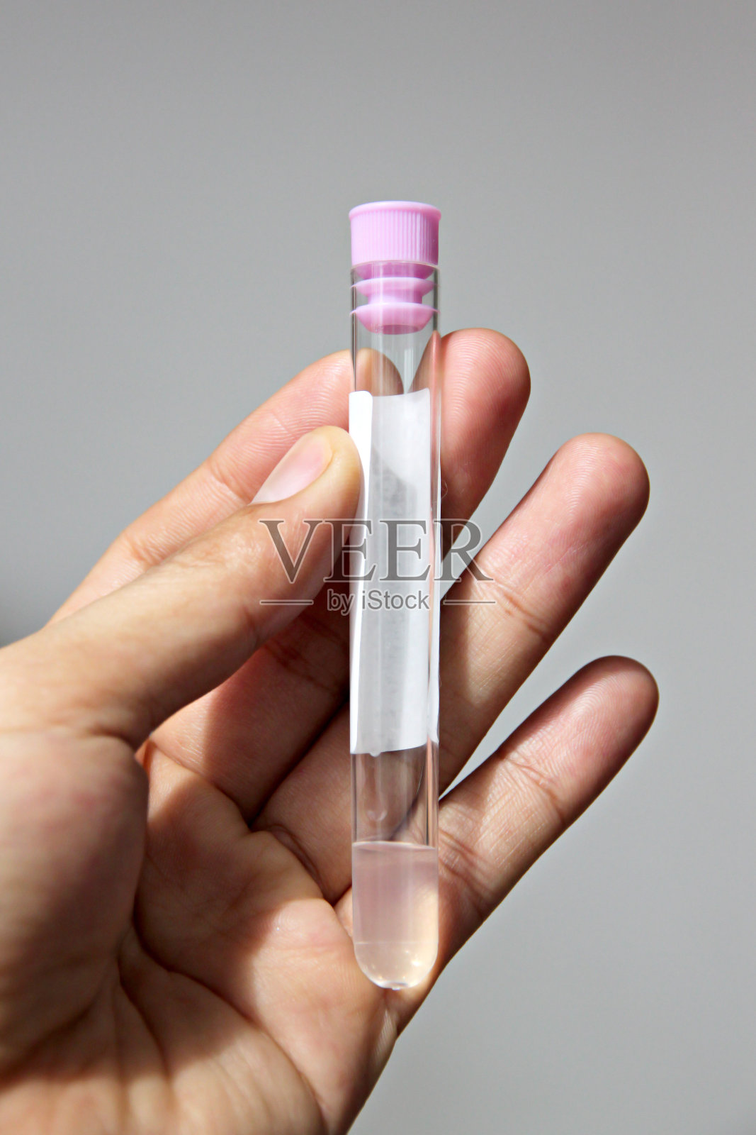 手上拿着大便试管。照片摄影图片