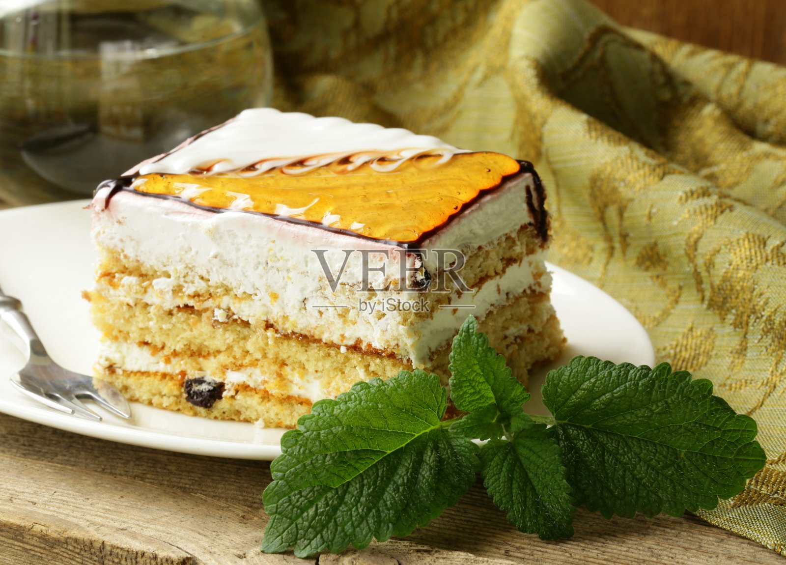 一块有焦糖糖霜和薄荷叶的蛋糕照片摄影图片