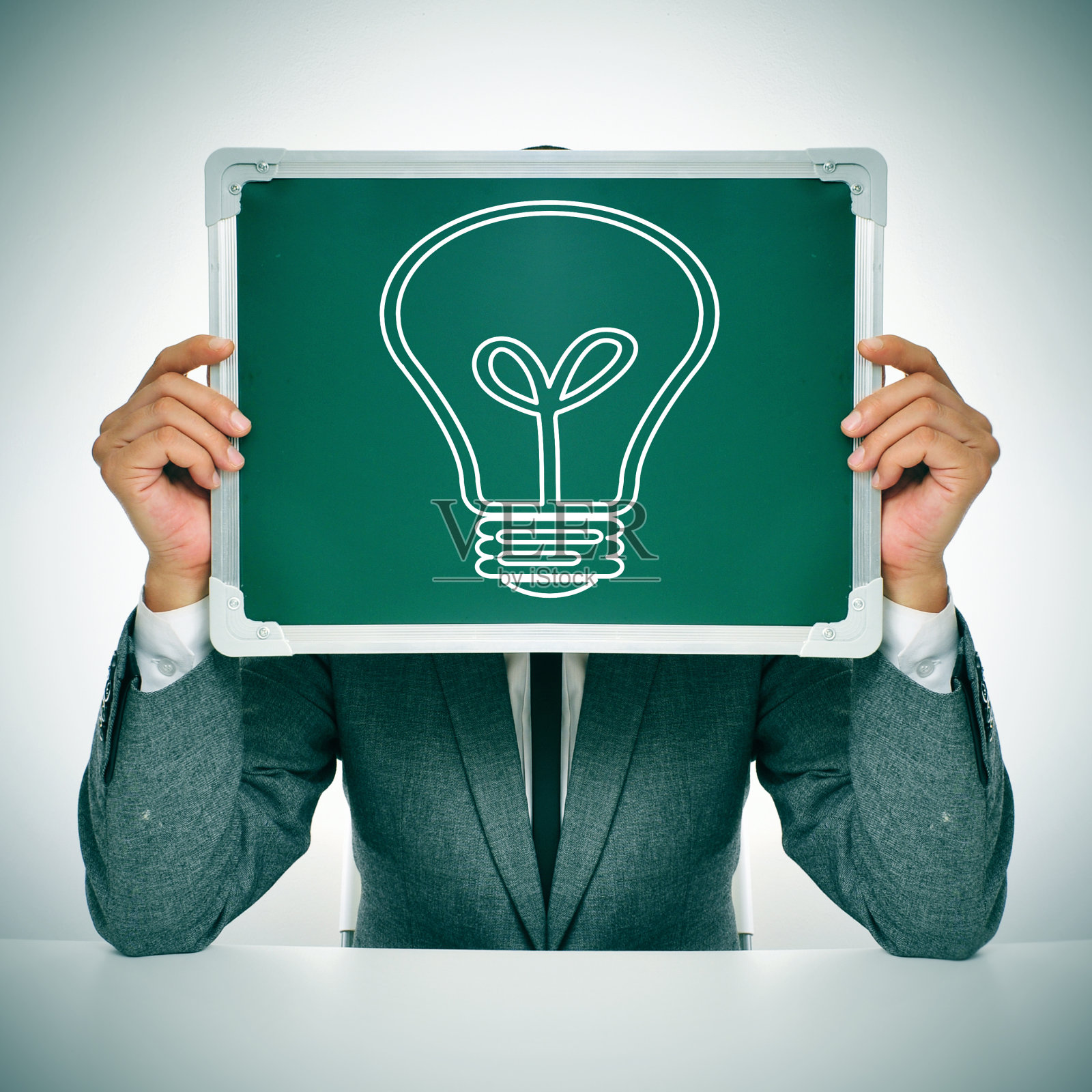 穿着西装，带着灯泡的男人照片摄影图片