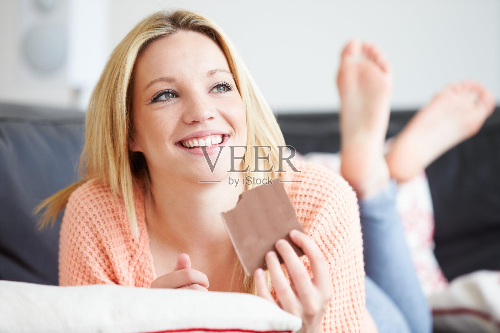 一个十几岁的女孩在家里吃巧克力照片摄影图片