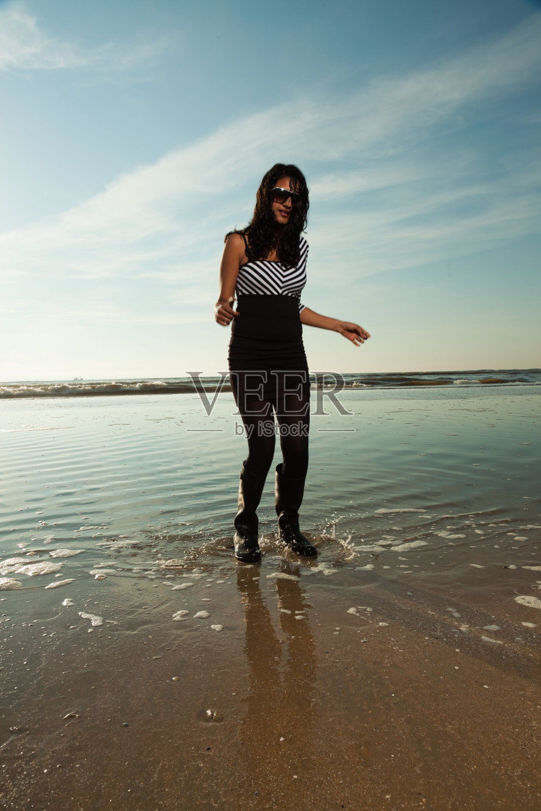 夏日沙滩上戴着墨镜的漂亮印度女孩。照片摄影图片