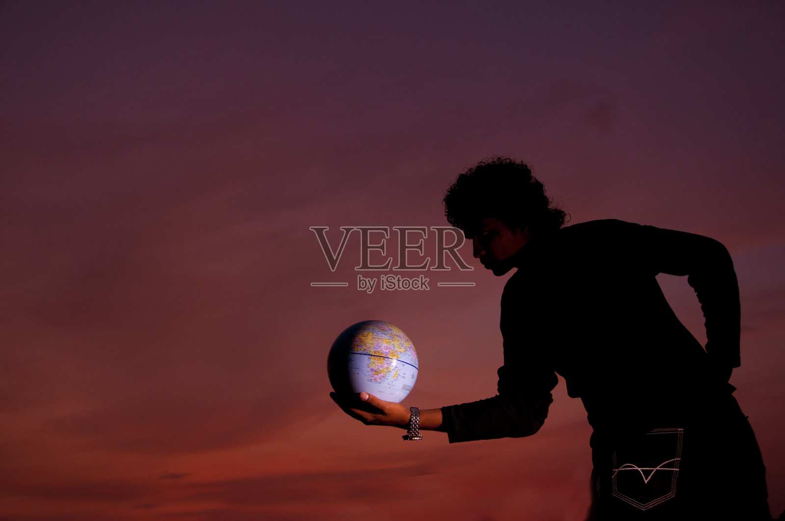 手里拿着一个地球仪照片摄影图片