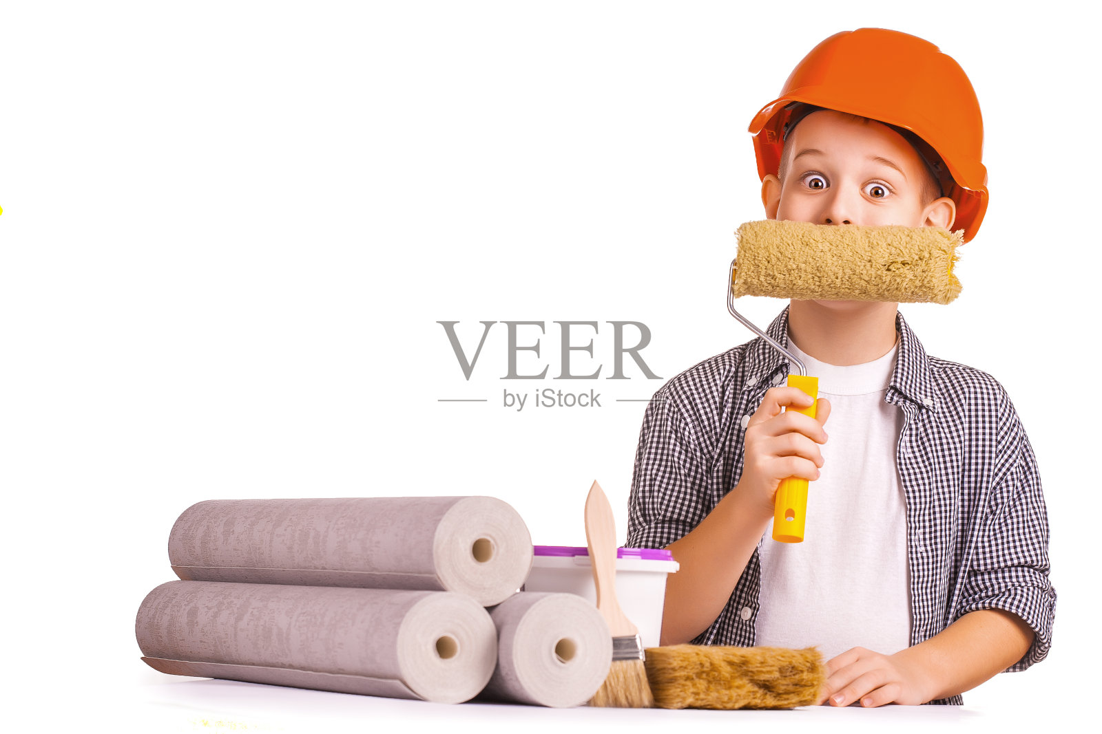 可爱的男孩拿着一卷墙纸和刷子。孤立的照片摄影图片