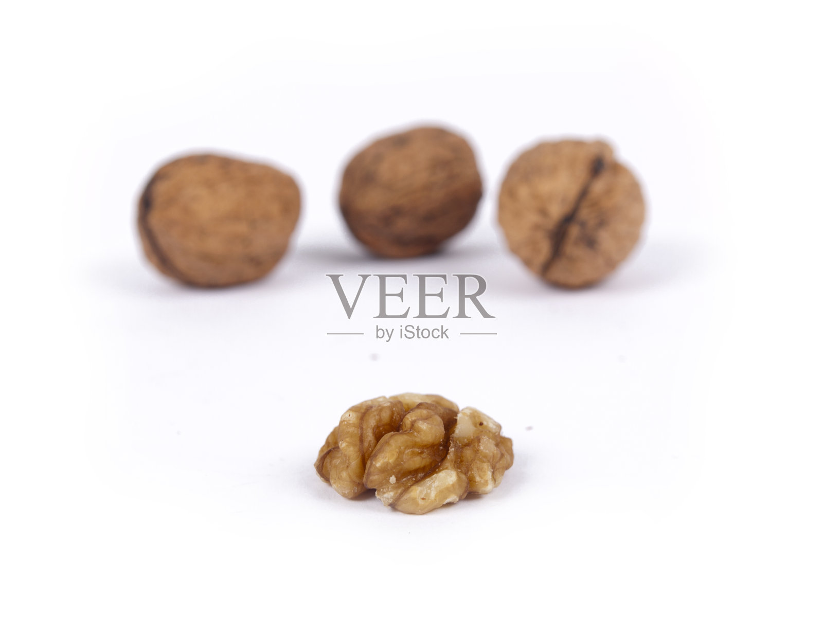 去皮核桃，后面盖上坚果壳照片摄影图片