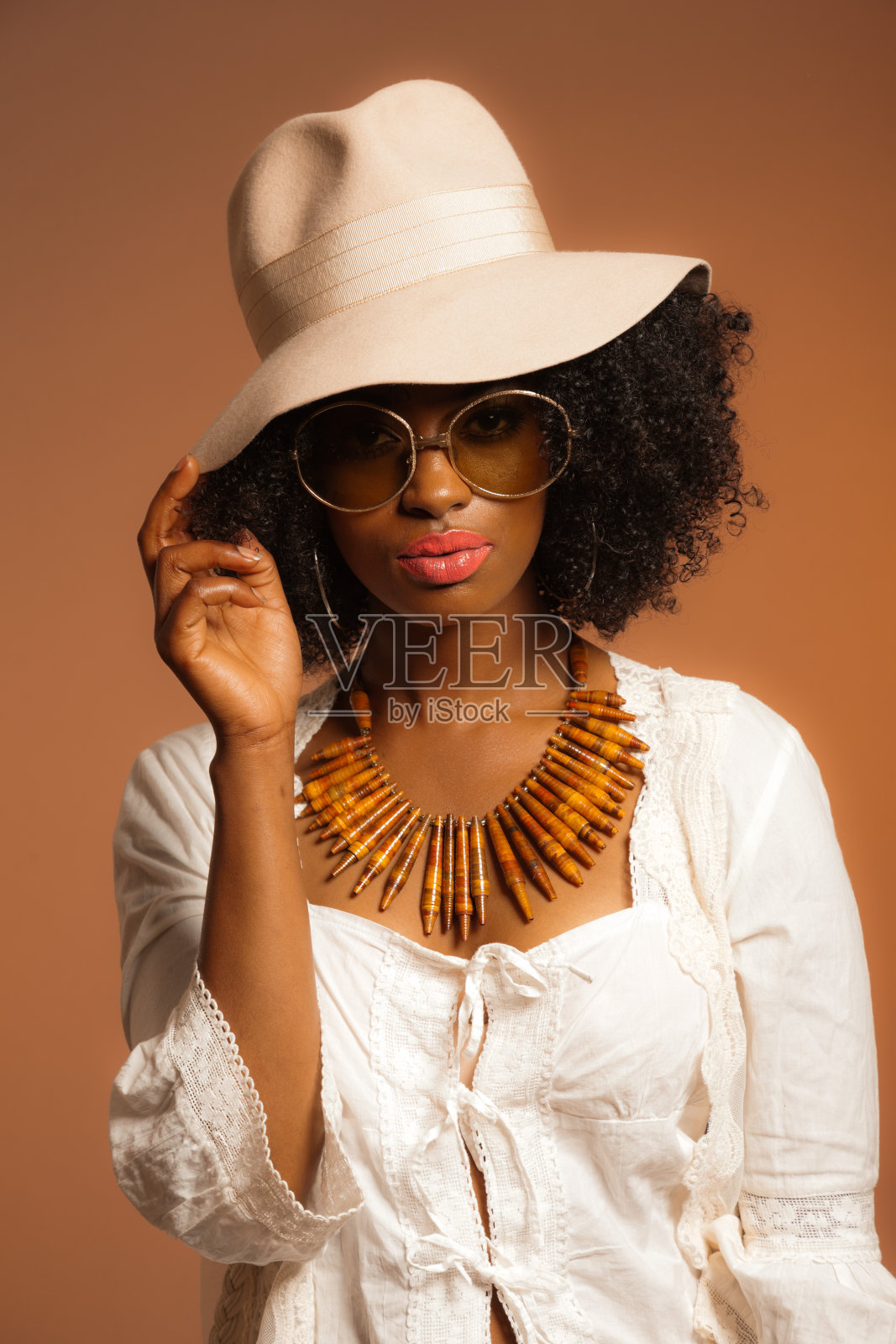 复古的70年代流行的非洲妇女，戴着太阳镜和白色的帽子。照片摄影图片