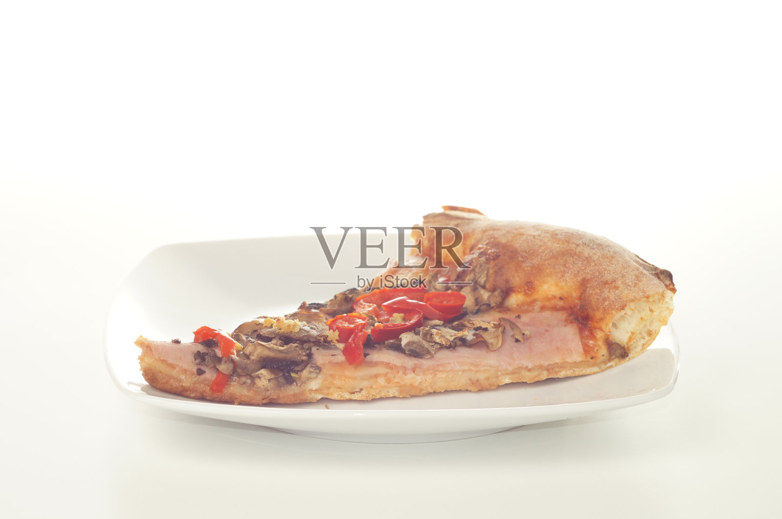 一片披萨放在盘子里照片摄影图片