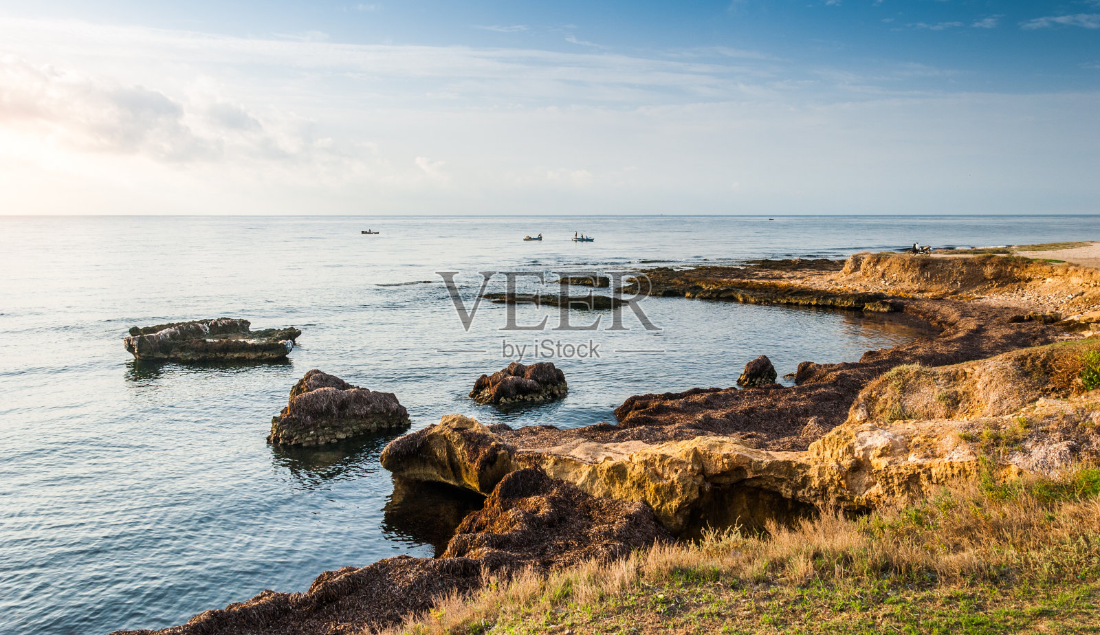 岩石海岸和看与渔民照片摄影图片