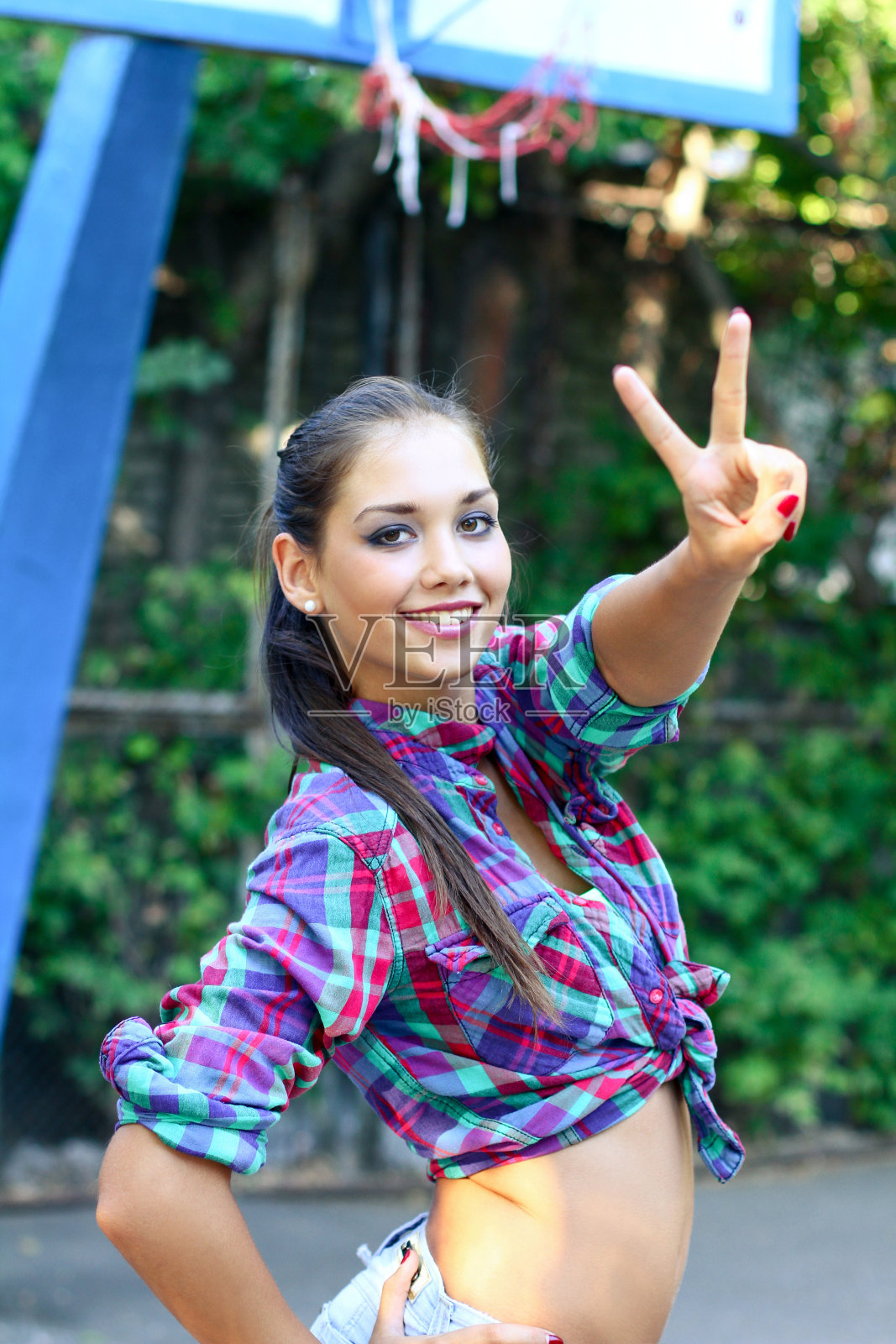 夏天，快乐的年轻女子在户外展示和平标志照片摄影图片