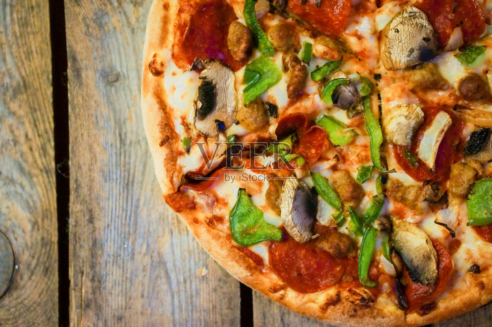 切成薄片的自家做的意大利辣香肠披萨在木制的乡村背景下照片摄影图片