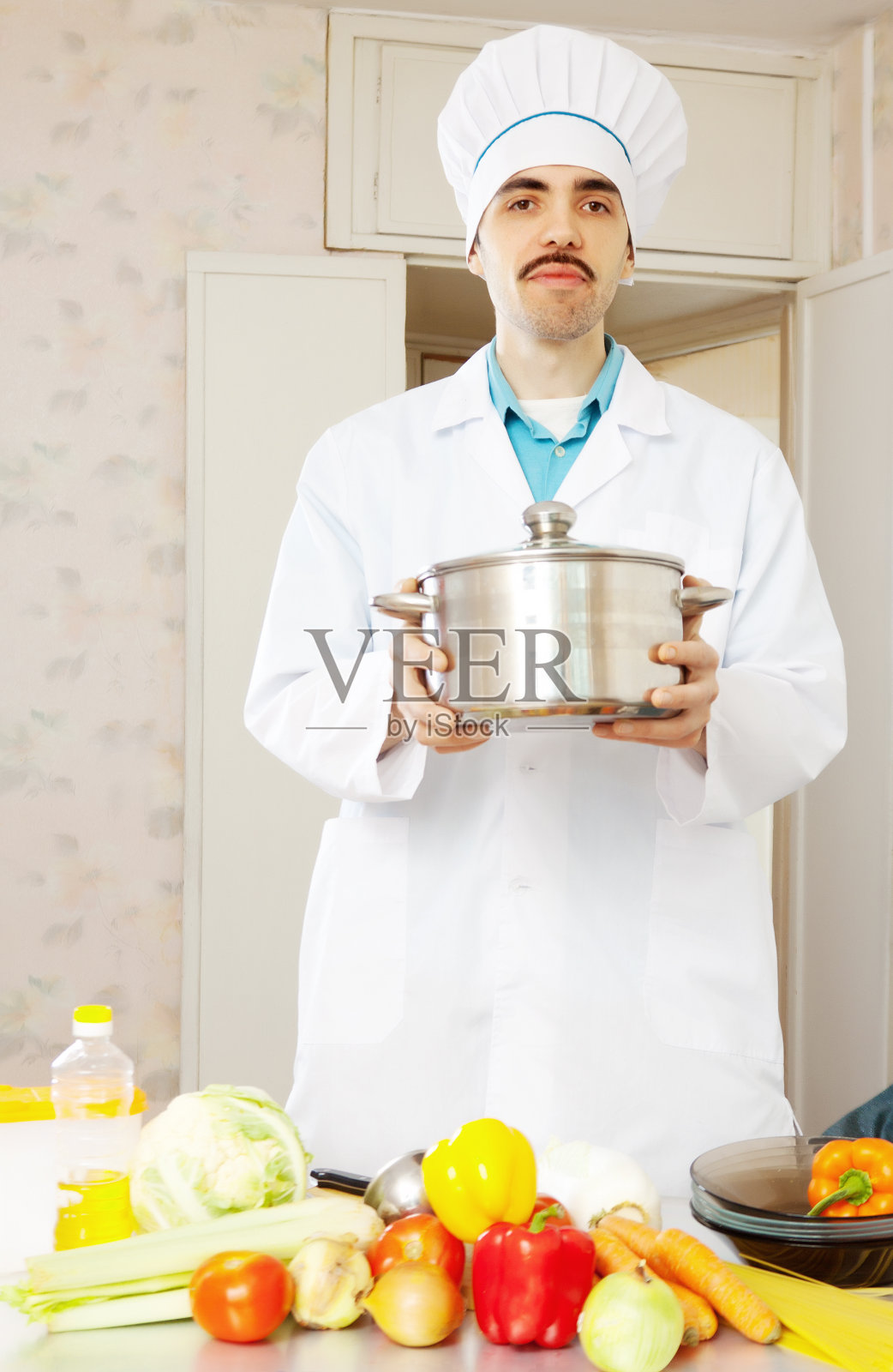 男厨师穿着制服和平底锅照片摄影图片