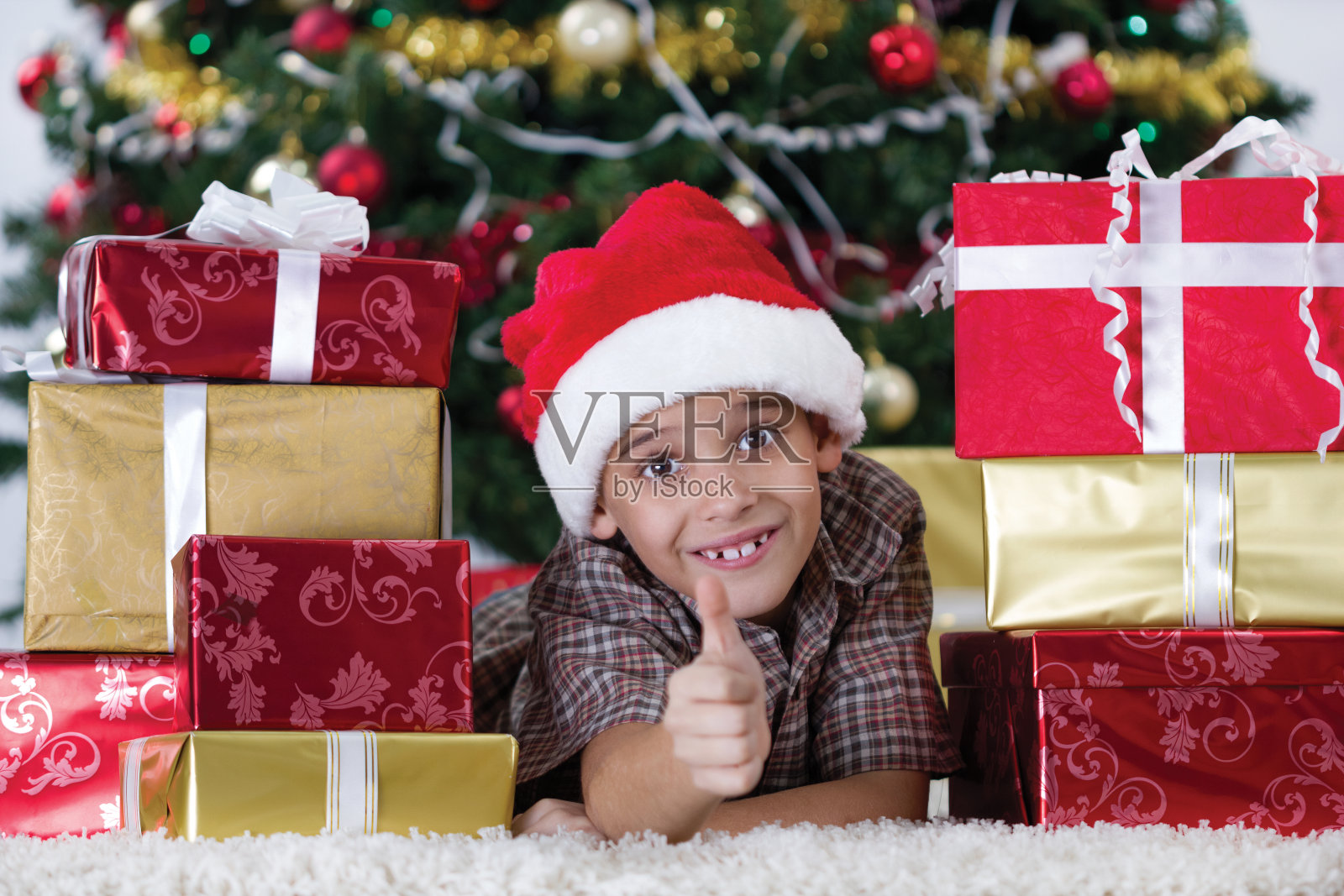 一个快乐的小男孩在圣诞树旁照片摄影图片