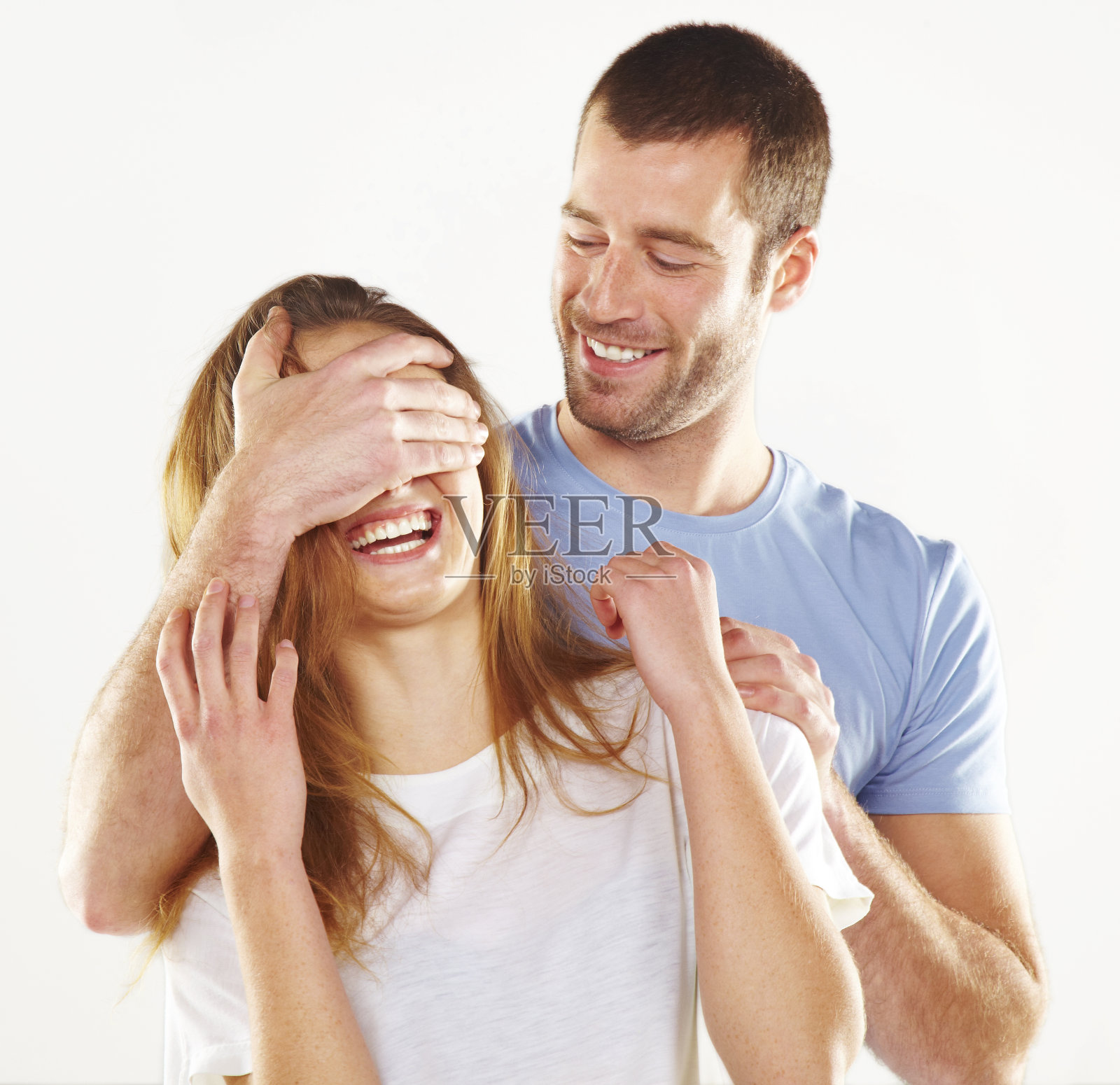 小男孩用手捂住她女朋友的眼睛。照片摄影图片