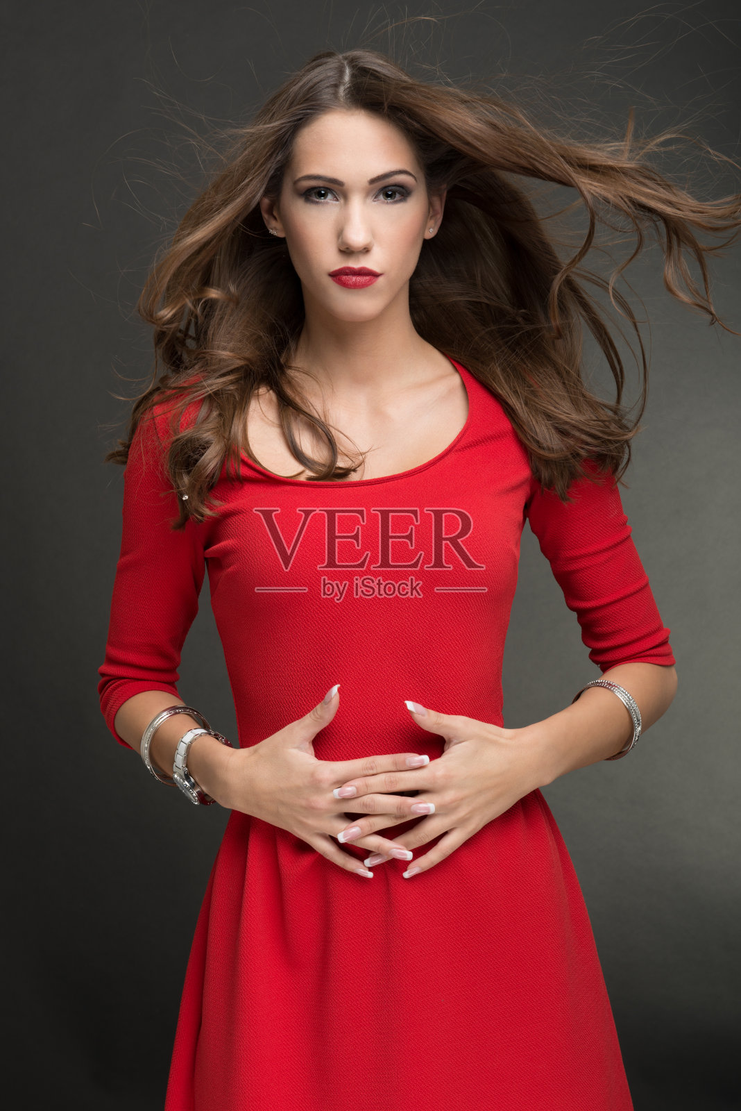 穿着红色连衣裙的迷人时装模特。照片摄影图片