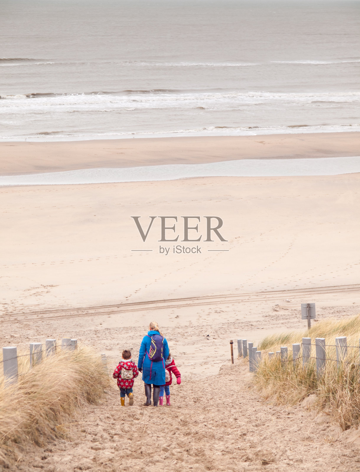 一个女人和两个小孩正走向海滩照片摄影图片