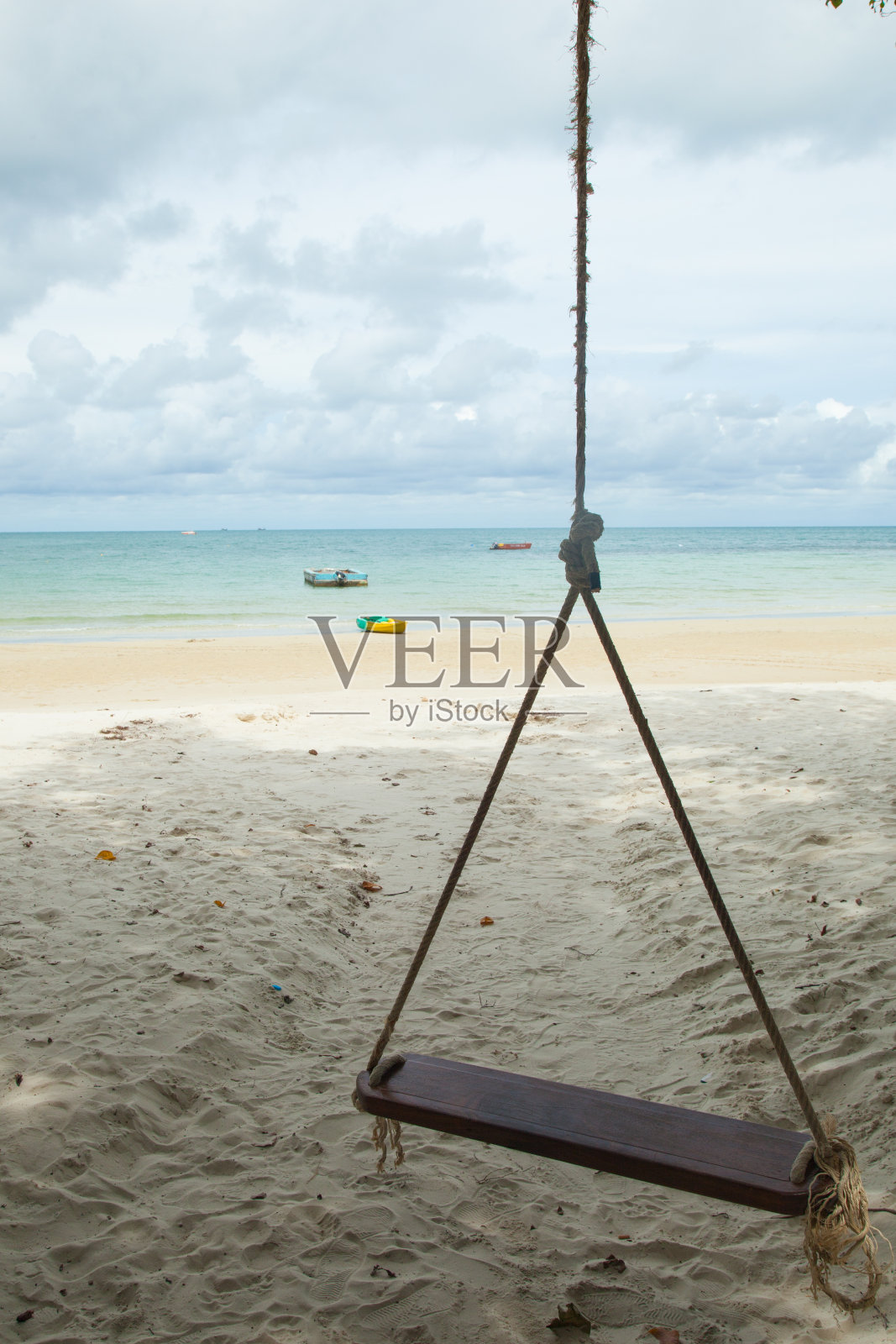 在海滩上荡秋千。照片摄影图片
