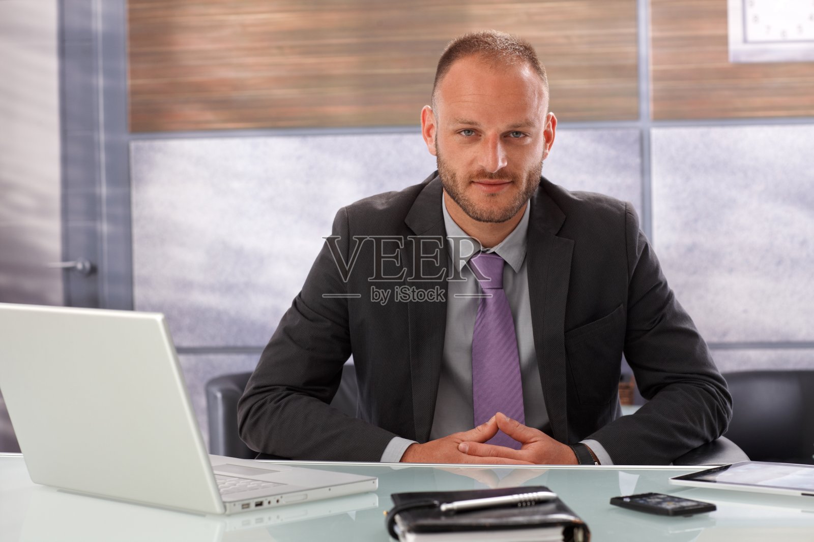 年轻的商人坐在电脑和计划桌前照片摄影图片