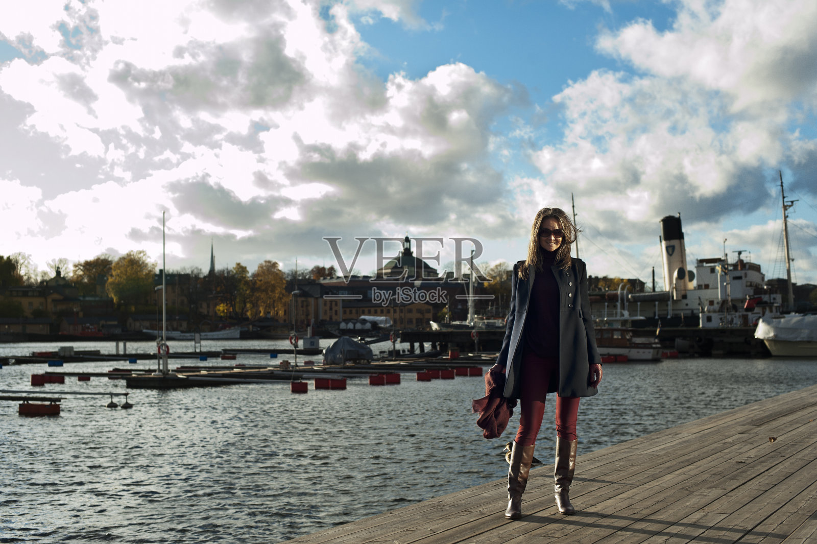 微笑的女子站在斯德哥尔摩的码头上照片摄影图片
