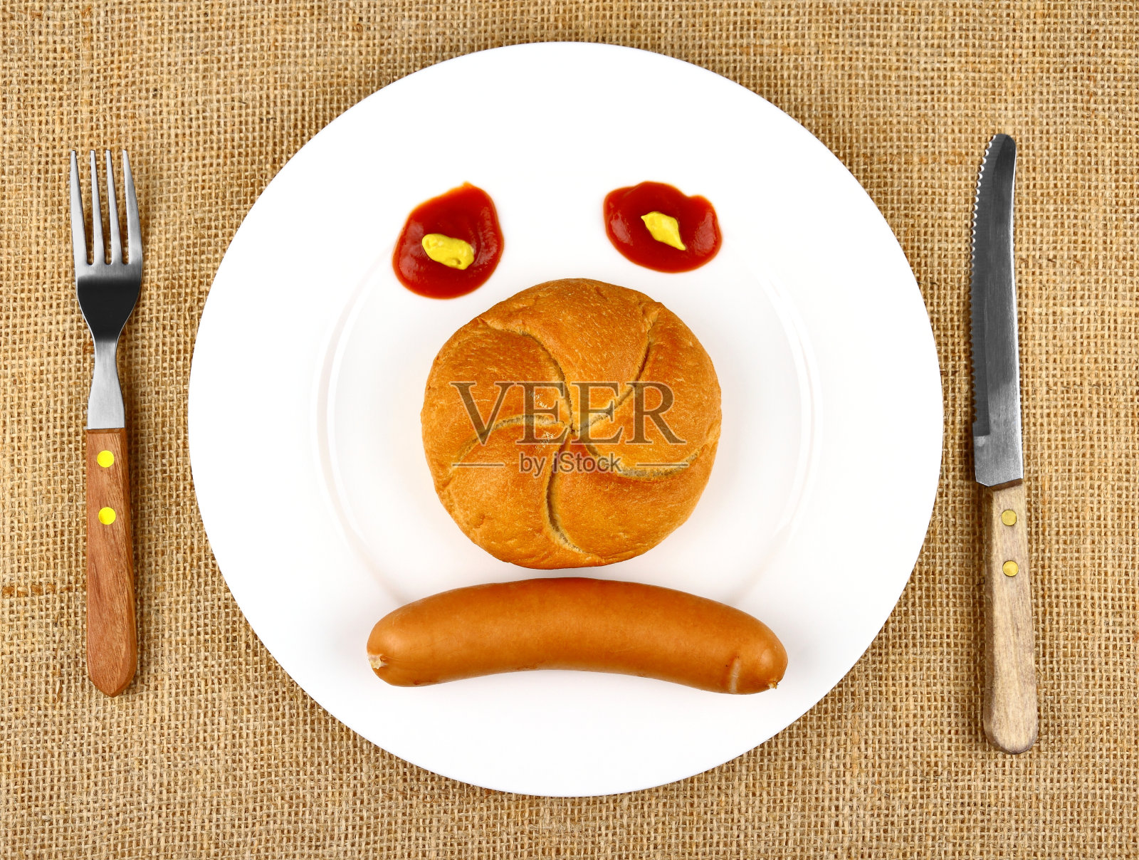 香肠配馒头放在盘子里当愁脸照片摄影图片