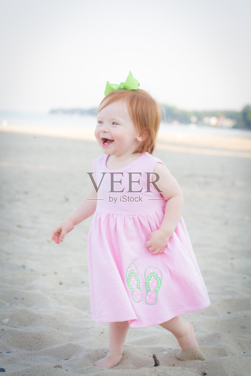 小红发小孩在沙滩上奔跑照片摄影图片