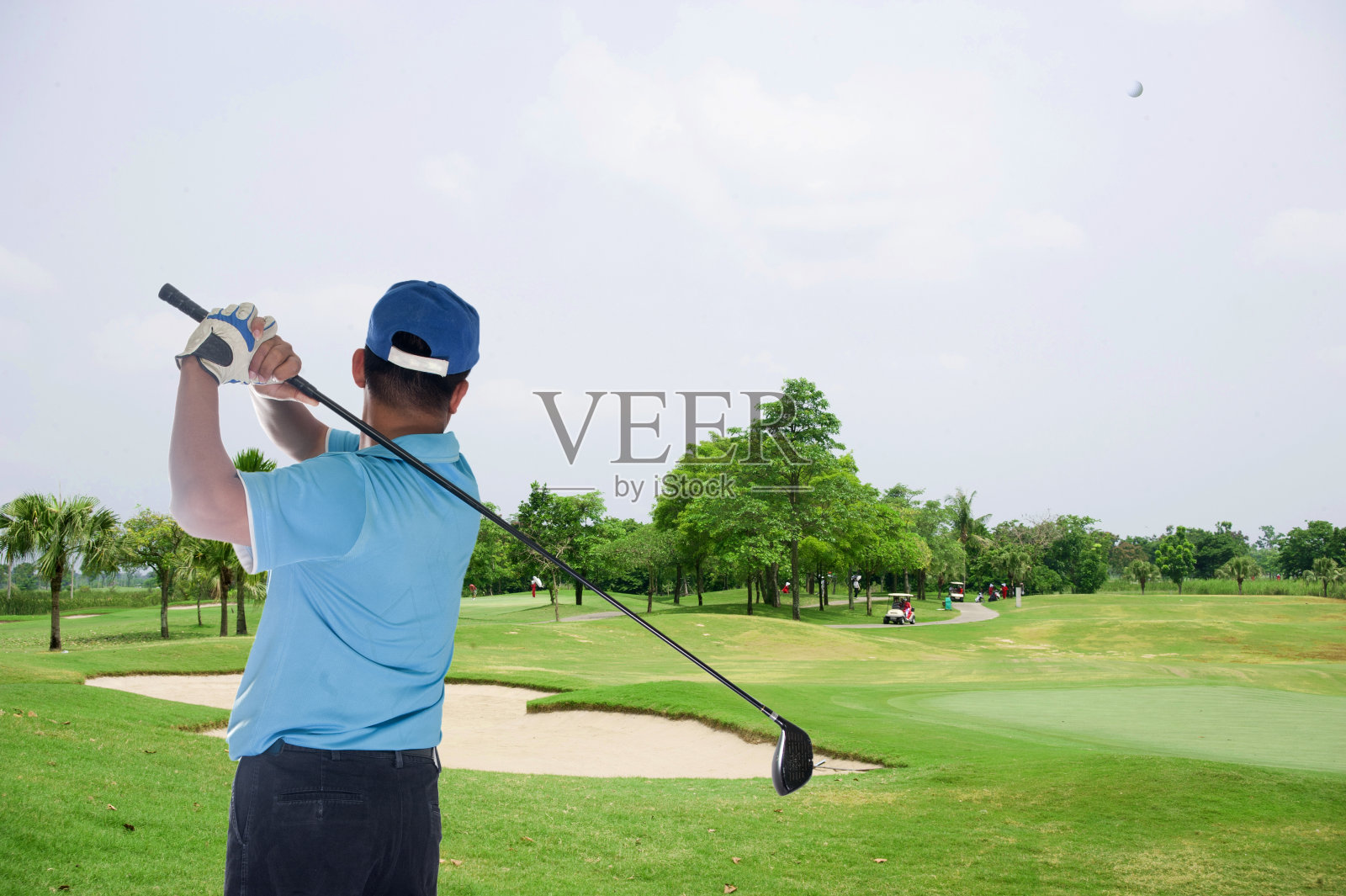 高尔夫球手在球道击球照片摄影图片