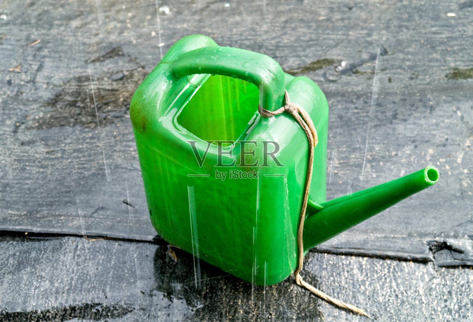 浇壶在倾盆大雨中照片摄影图片
