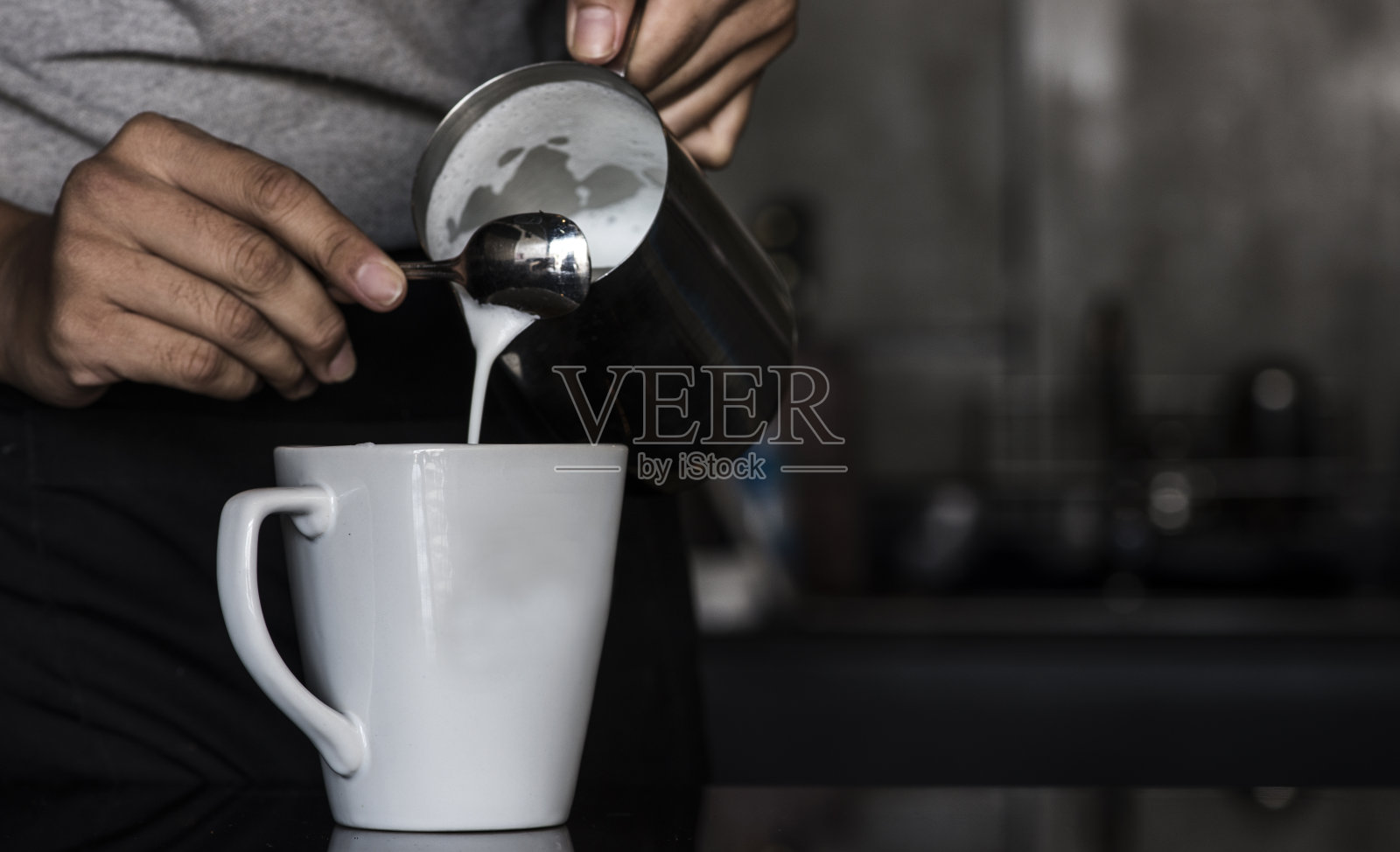 咖啡师在他的咖啡店或咖啡馆里制作卡布奇诺，特写照片摄影图片