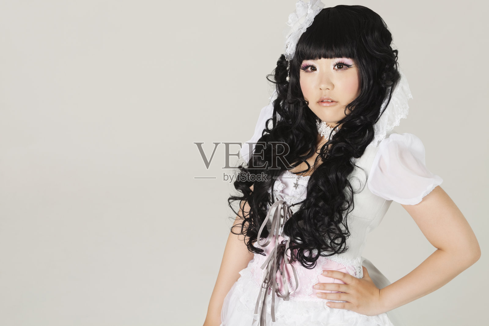 可爱的年轻女子在娃娃服装站照片摄影图片