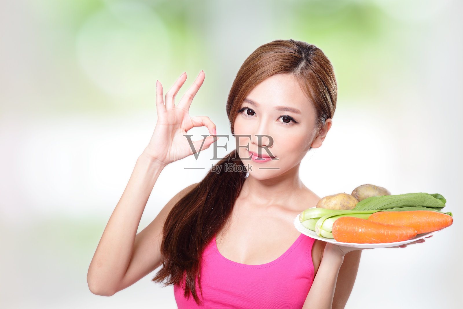 拿着绿色蔬菜和胡萝卜的女人照片摄影图片