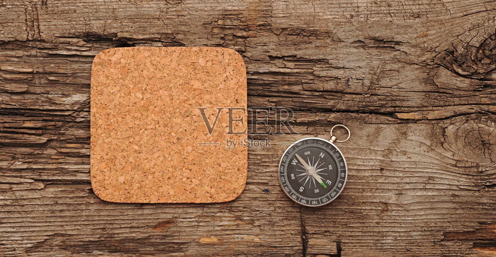 软木记忆板和指南针在旧的木制背景上照片摄影图片