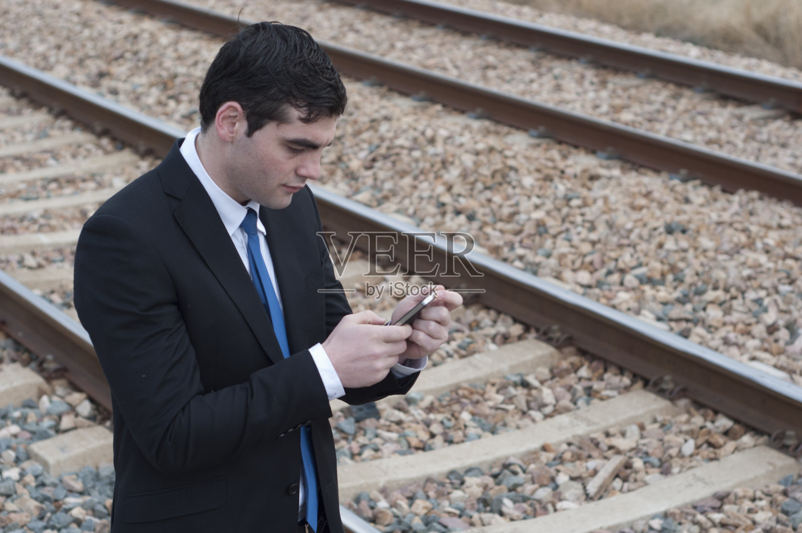 西装男在看他的智能手机照片摄影图片