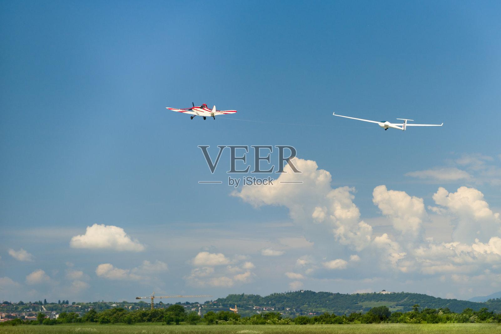 红色的飞机拖着滑翔机在空中飞行照片摄影图片