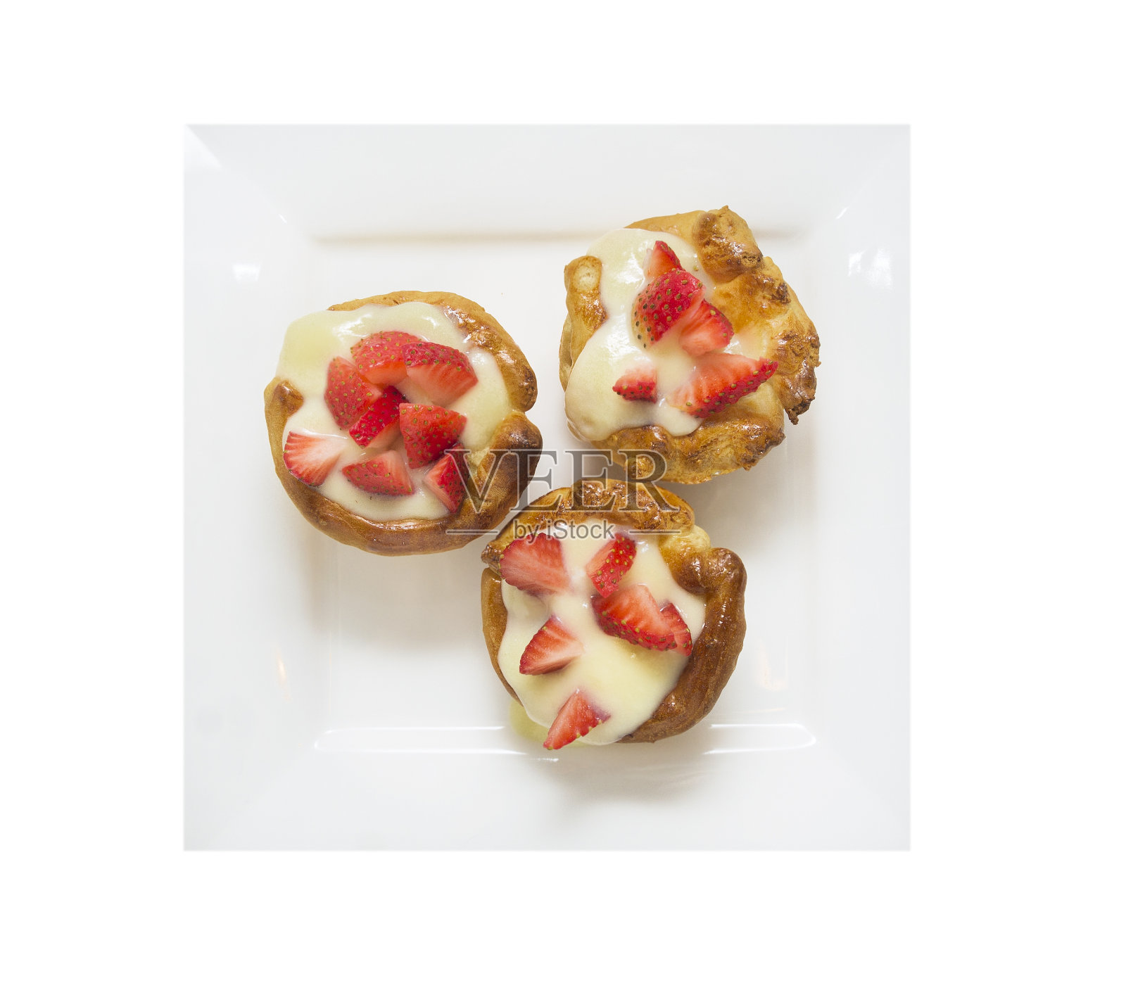 三个蛋糕，蛋奶沙司和草莓，在白色盘子，孤立照片摄影图片