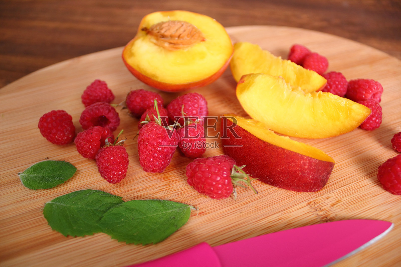 切板上的覆盆子和桃子片照片摄影图片