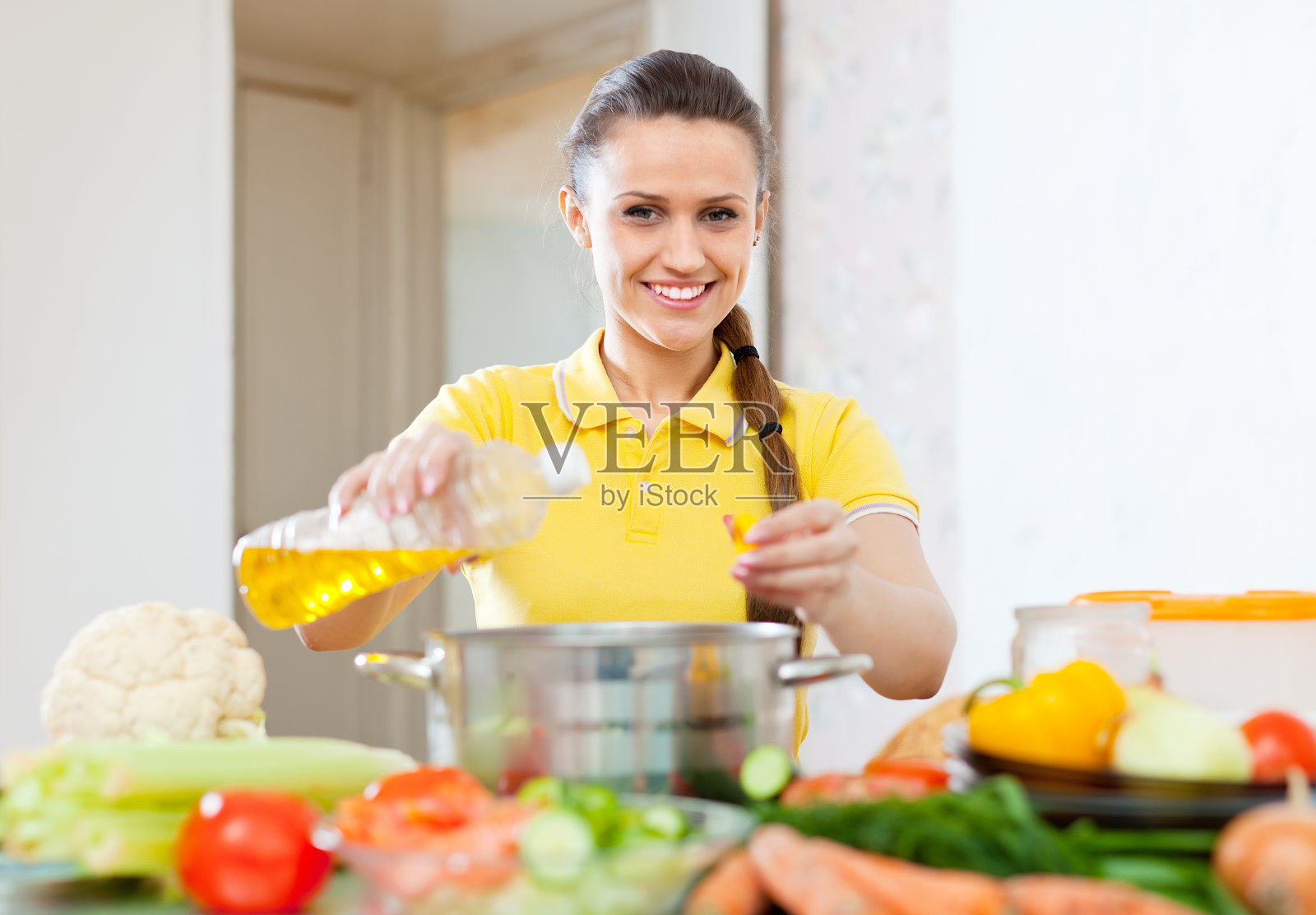 往锅里倒油的女人照片摄影图片