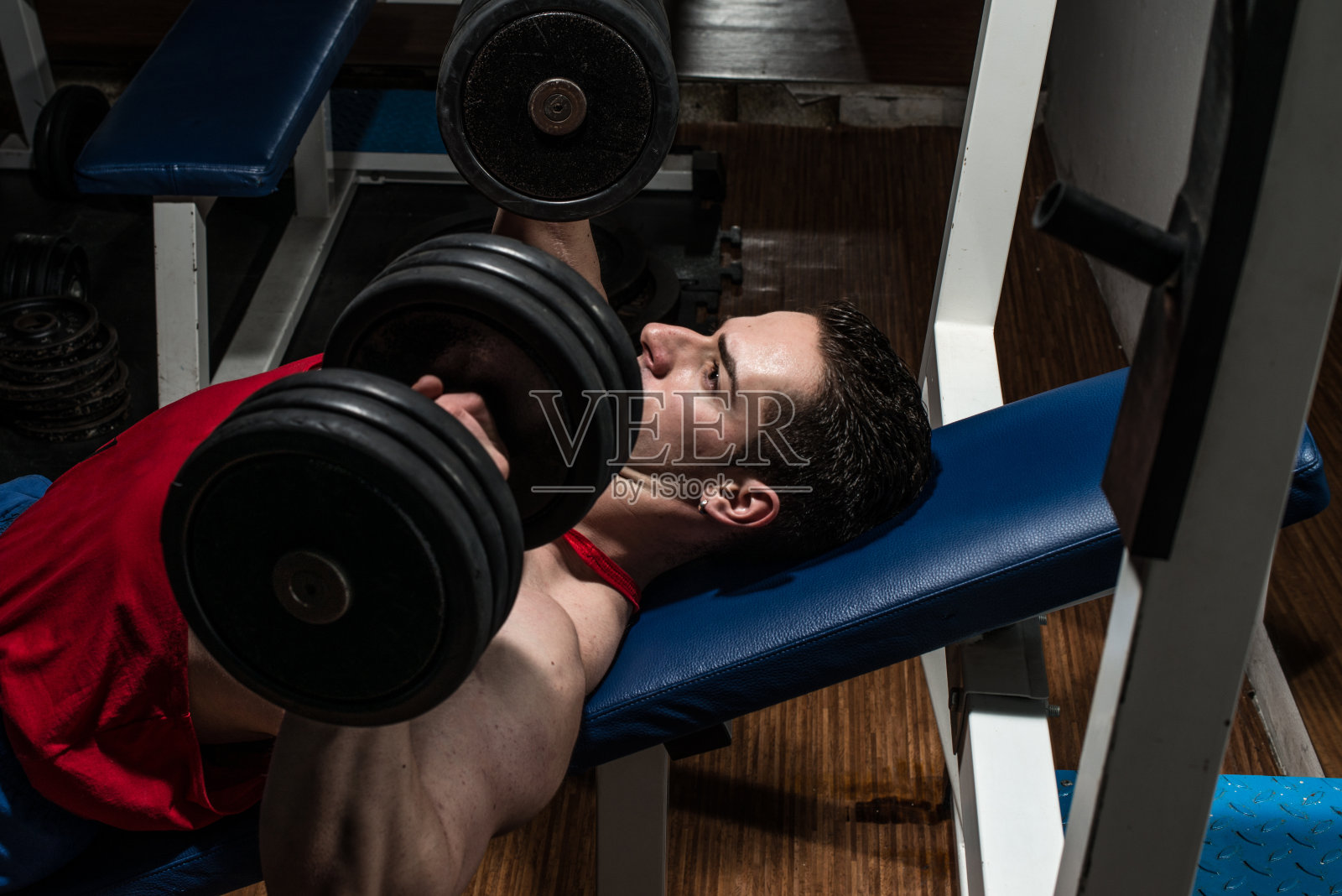 年轻的健美运动员在做胸部卧推照片摄影图片