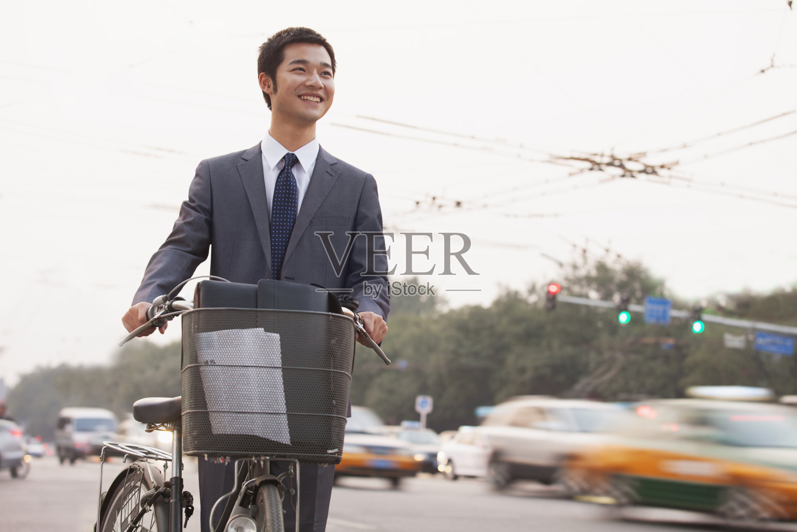 年轻的商人骑着自行车在北京的大街上照片摄影图片