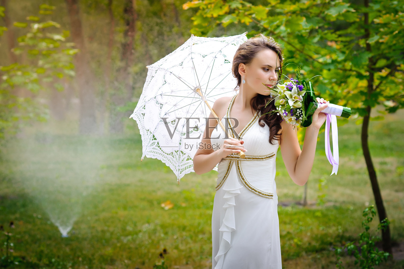 新郎和新娘在公园里。新娘的花束流照片摄影图片