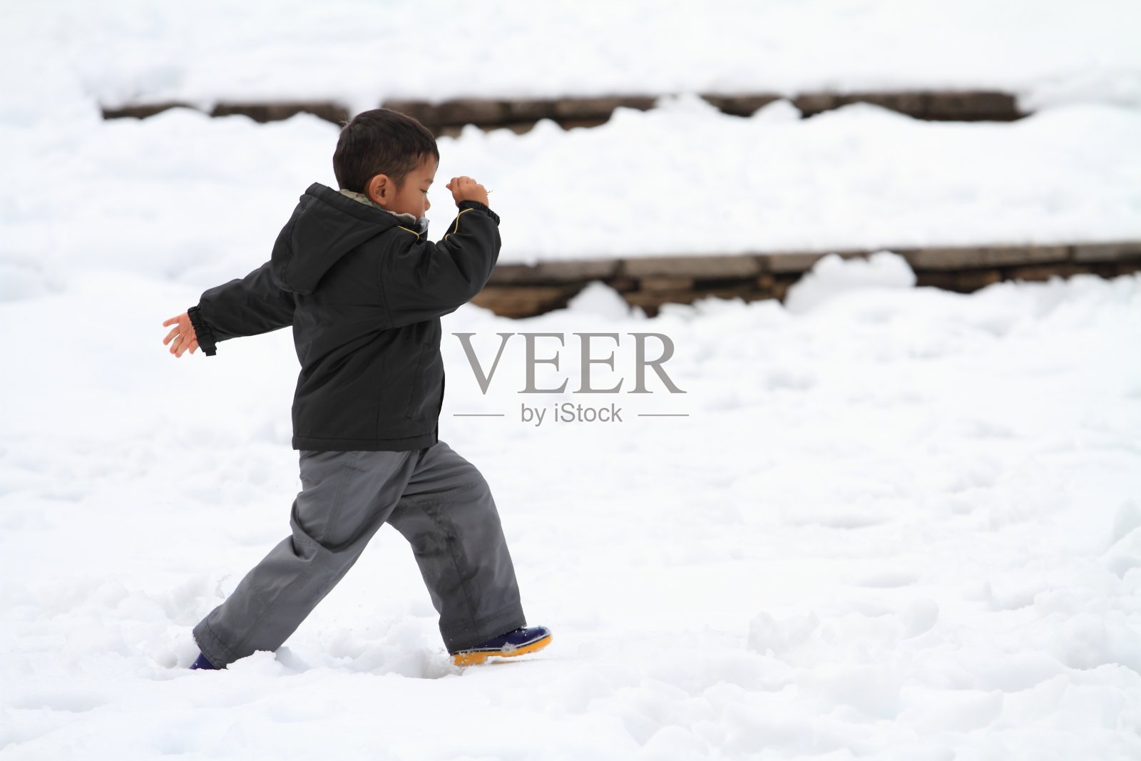 男孩在雪地上奔跑照片摄影图片