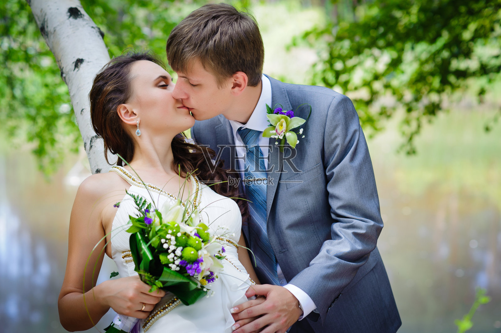 新郎和新娘在公园里。新娘的花束流照片摄影图片