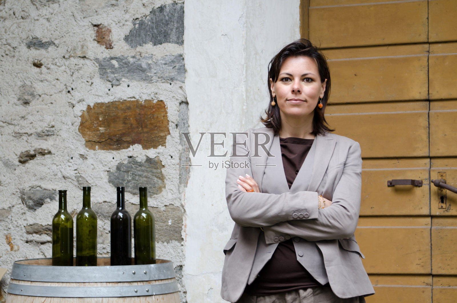 站在酒瓶旁边的优雅女人照片摄影图片