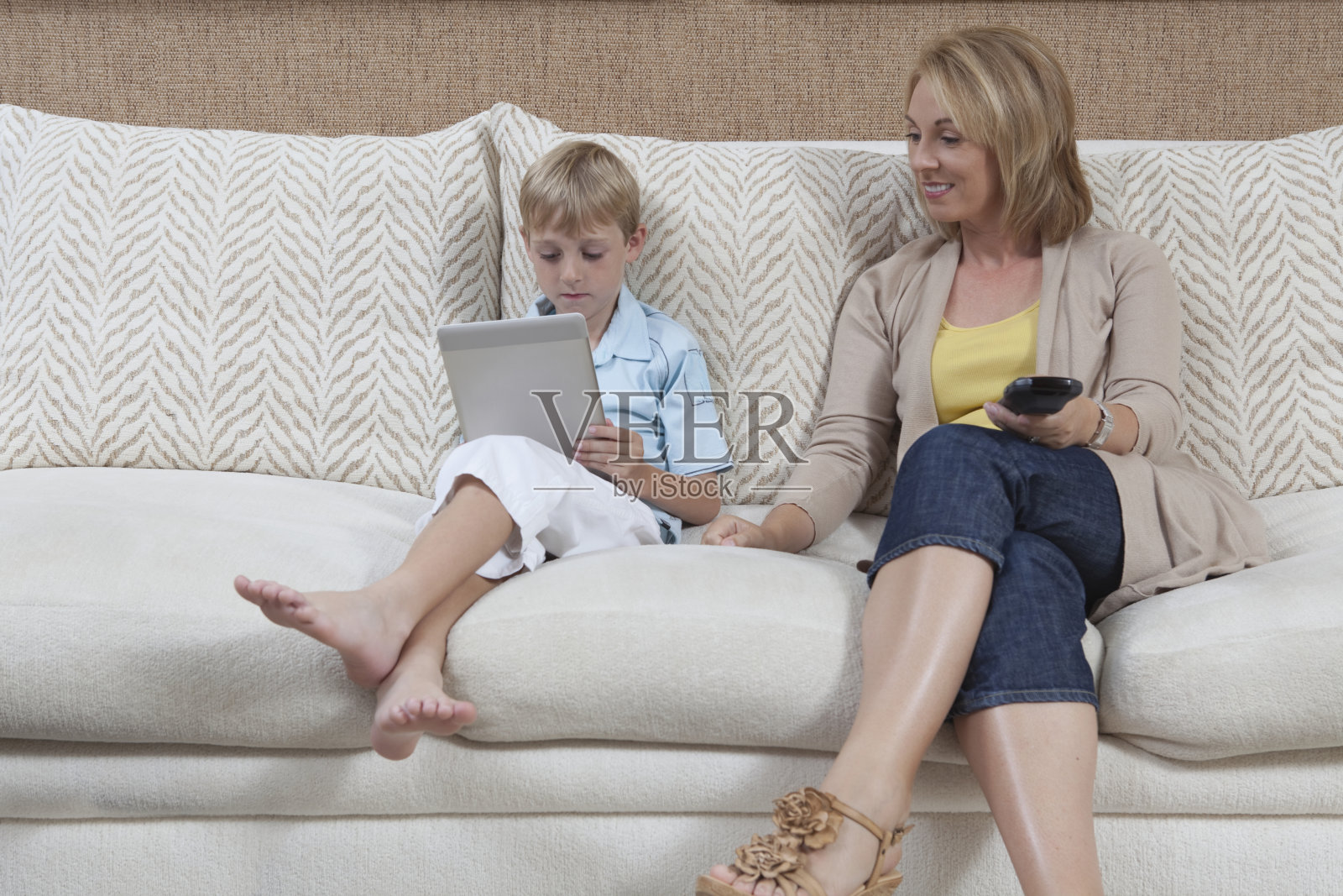 坐在沙发上的母亲看着儿子照片摄影图片