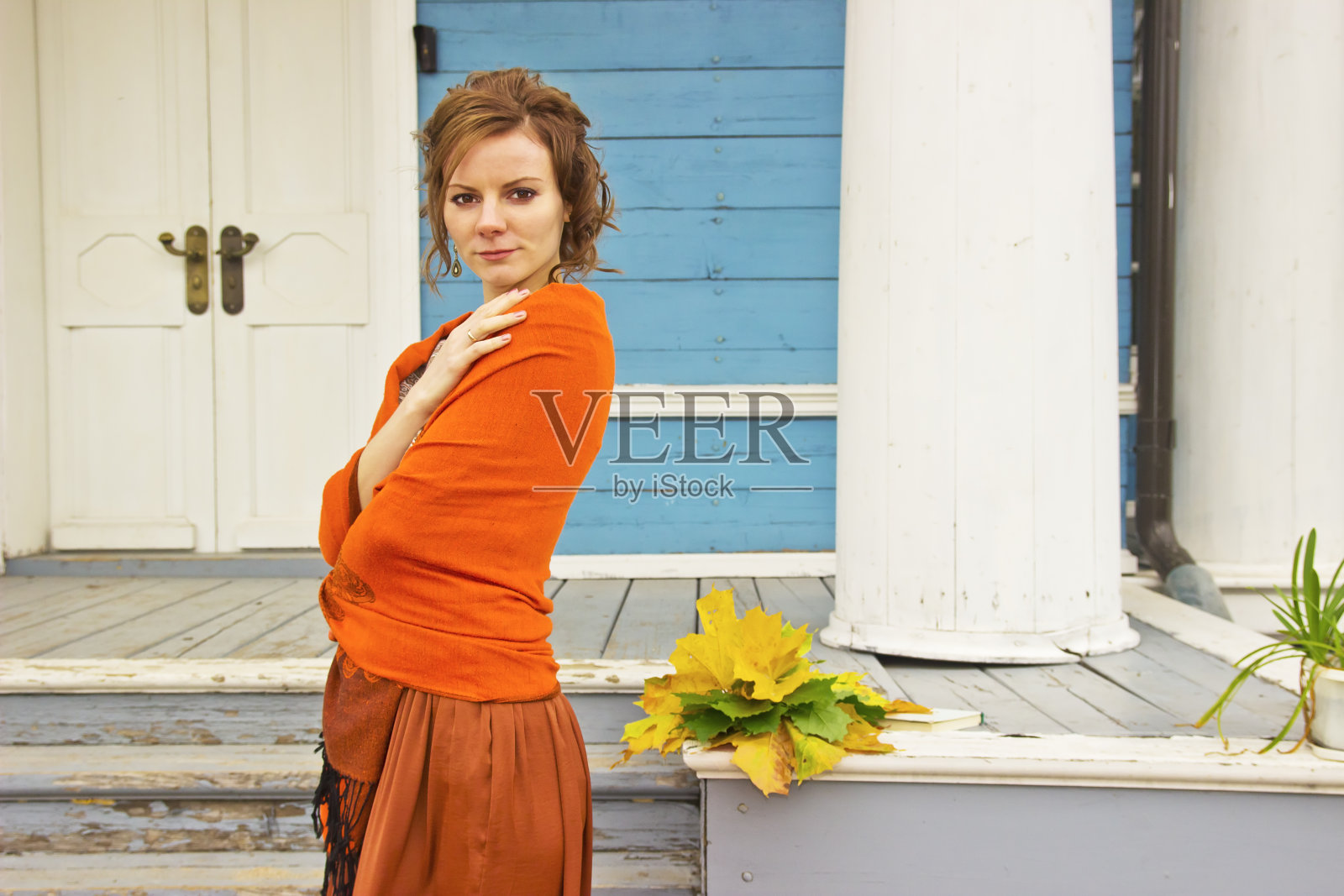 年轻美丽的黑发女子肖像与枫叶照片摄影图片