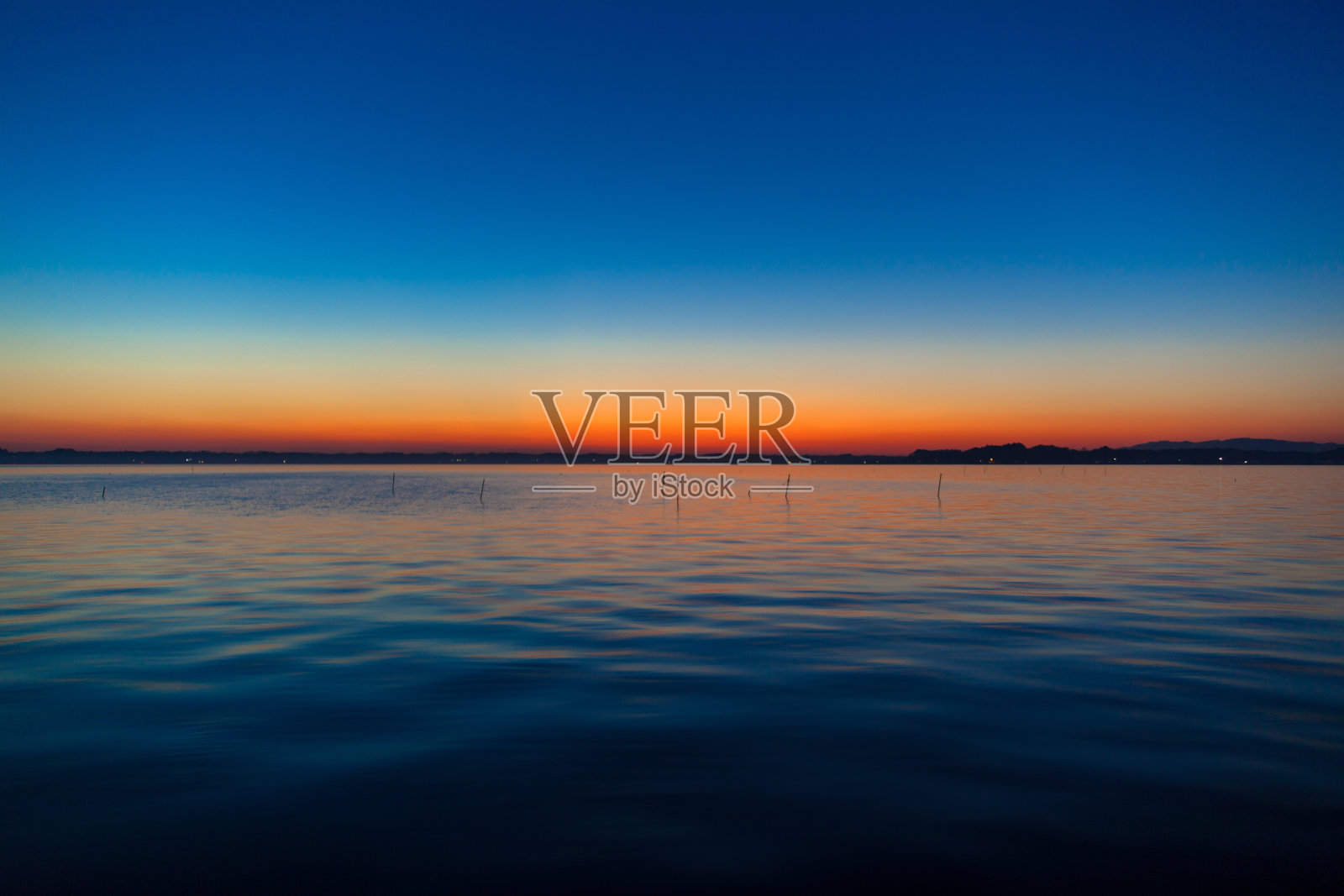 霞光湖上的日落呈现出蓝色和橙色的渐变照片摄影图片