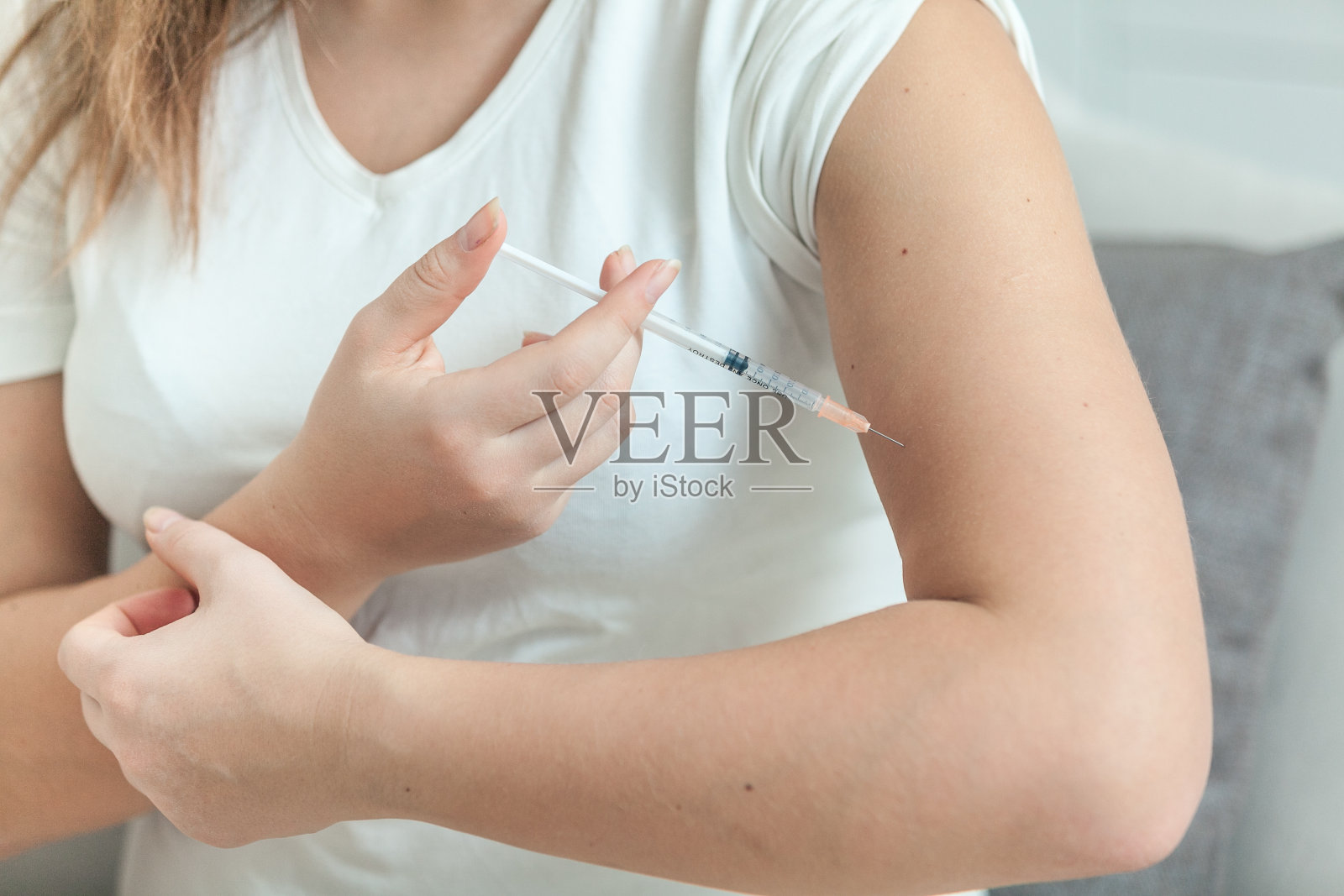 手里拿着注射器做注射的女人照片摄影图片