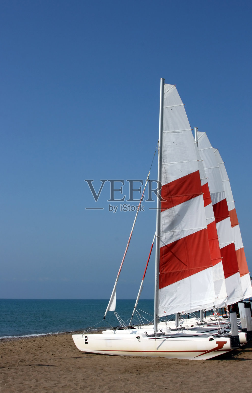 有帆的游艇在海岸边出售照片摄影图片