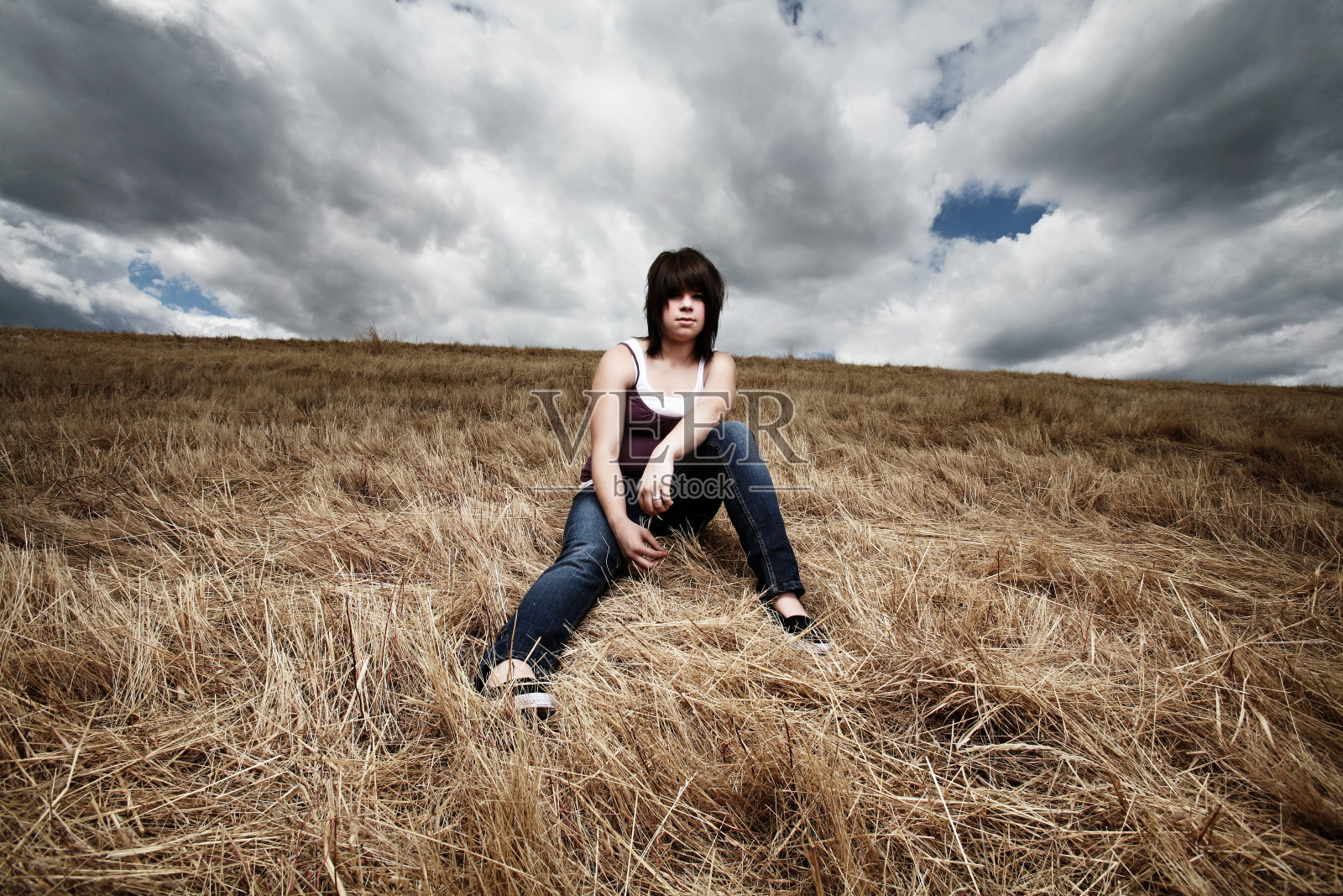坐在暴风雨下的年轻女子照片摄影图片