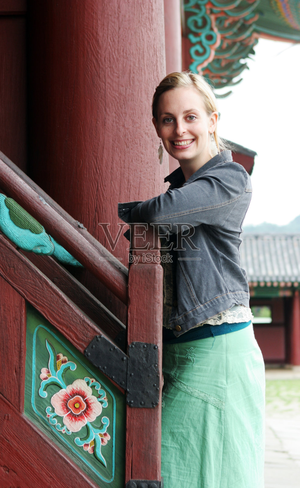 一名女子倚靠在首尔一座韩国寺庙的楼梯上照片摄影图片