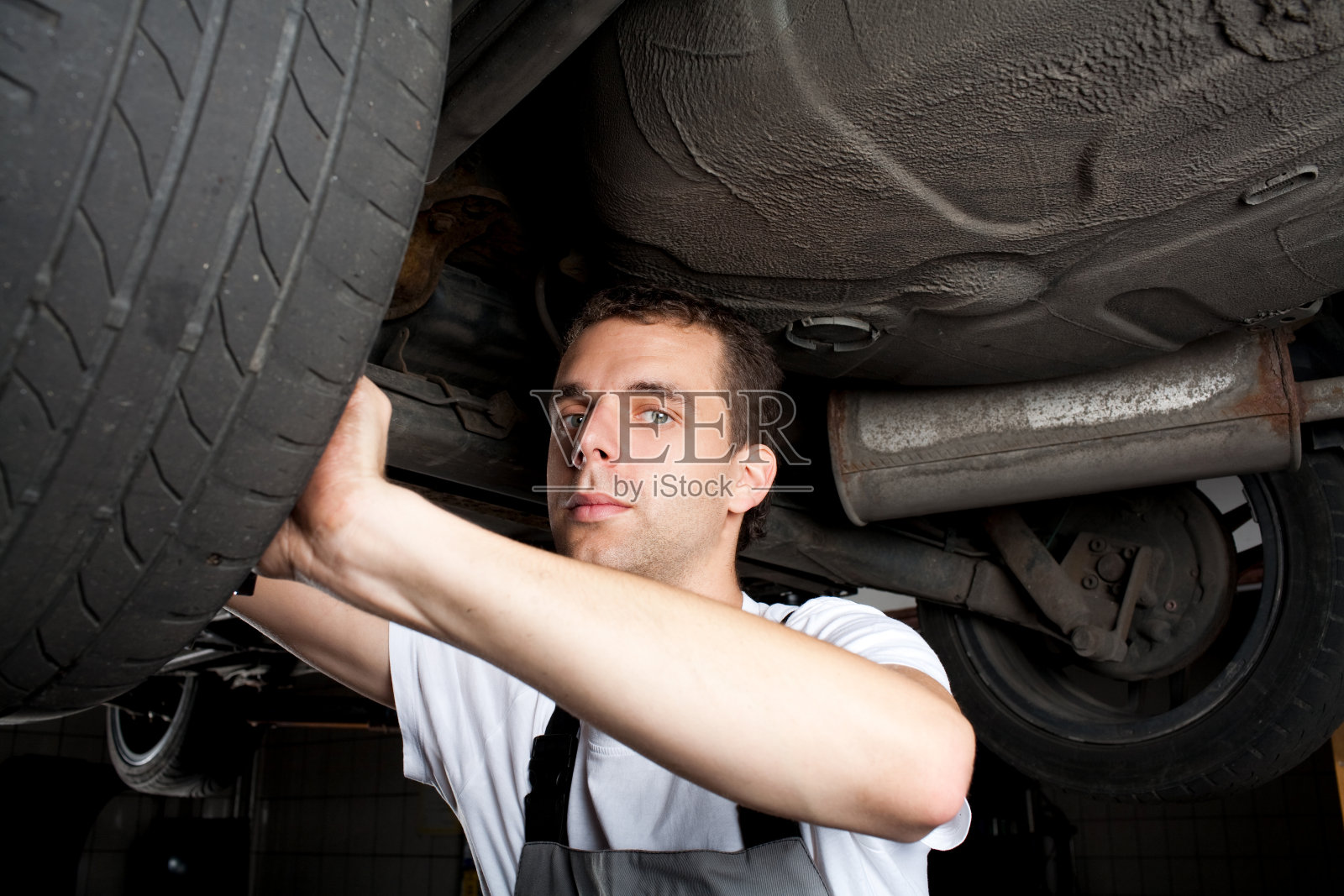 机修工用扳手在汽车下面工作的特写照片摄影图片